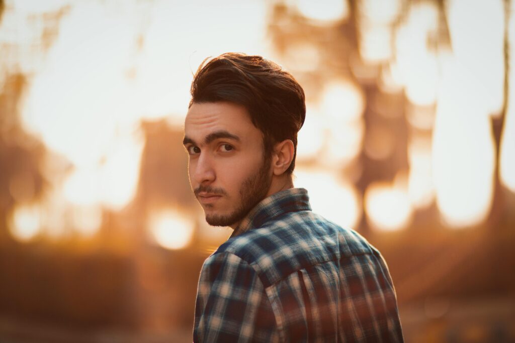 Portrait of a stylish young man in Tehran at sunset, exuding modern fashion elegance.