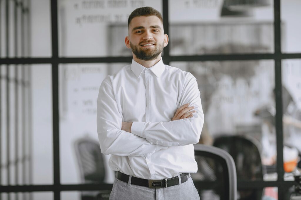 Portrait of a smiling businessman standing confidently in a modern office setting.